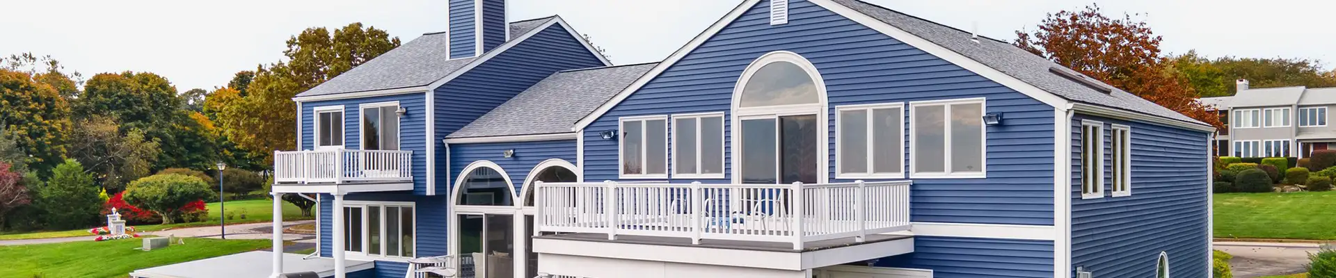 home with new roof, blue siding, and white framed windows